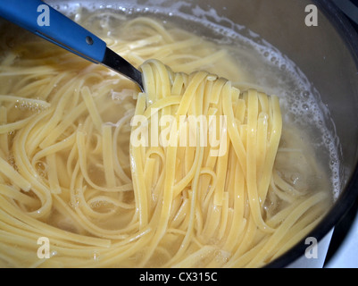 Linguine (also 'linguini') is a form of pasta — flat like fettuccine and trenette. Cooking in pot of boiling water Stock Photo