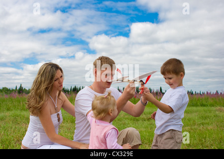 Happy family launching toy aircraft model together Stock Photo