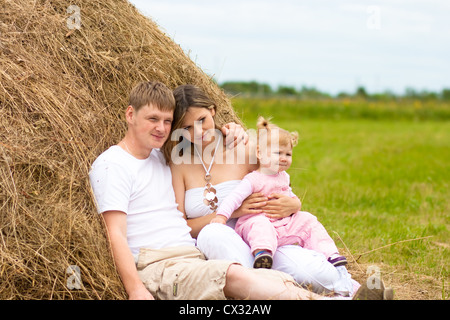 Happy family in haystack or hayrick Stock Photo