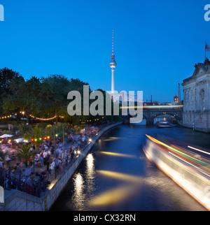 Strand bar on Spree river in Berlin at night, people dancing, boat passing Stock Photo