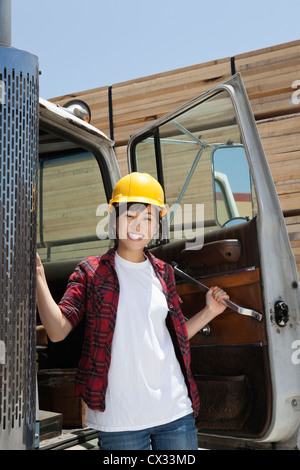 Portrait of an Asian female industrial worker standing by vehicle door Stock Photo