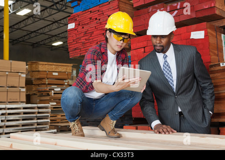 Female industrial worker showing something on tablet PC to male engineer Stock Photo