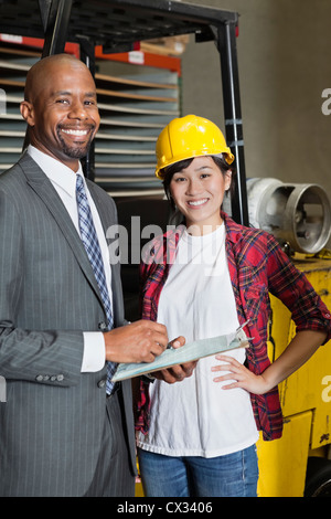 Portrait of female industrial worker standing with male inspector Stock Photo