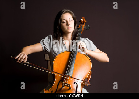Portrait of beautiful young cellist immersed passionate in her music. Stock Photo
