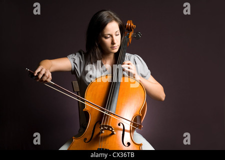 Passionate real artist, young woman playing her classical instrument. Stock Photo