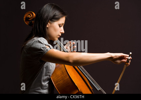 Portrait of beautiful young cellist immersed passionate in her music. Stock Photo