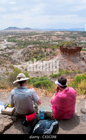 Tanzania Africa Olduvai Gorge tourists looking at famous gorge archelogy ruins of Dr Louis and Mary Leaky in 1931 Stock Photo