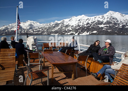 Passengers relaxing on sun deck of small cruise ship. Glacier Bay, Alaska. Stock Photo