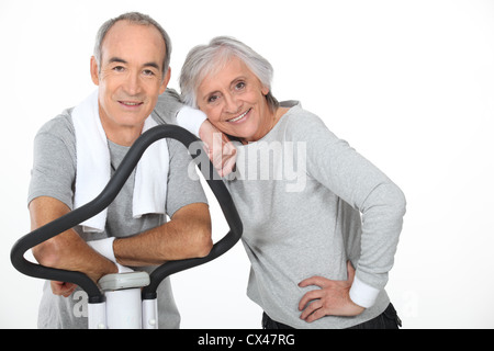 Senior couple using gym equipment Stock Photo