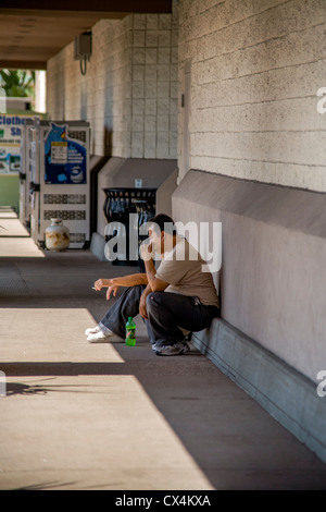 Two Hispanic warehousemen smoke cigarettes outside a hardware supply company in Laguna Niguel, CA. Stock Photo