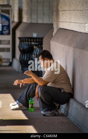 Two Hispanic warehousemen smoke cigarettes outside a hardware supply company in Laguna Niguel, CA. Stock Photo