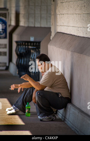 Two Hispanic warehousemen smoke cigarettes outside a hardware supply company in Laguna Niguel, CA. Stock Photo