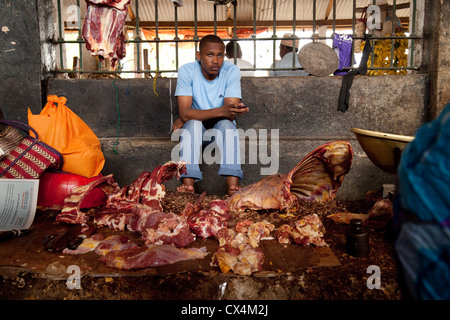 Butcher with meat for sale in the indoor food market, Darajani market, Stone Town, Zanzibar, Africa Stock Photo