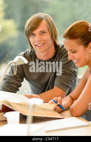 Teens reading book studying in high-school library campus young students Stock Photo