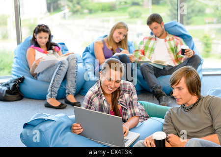 Students sitting on beanbags study room high-school teens happy Stock Photo