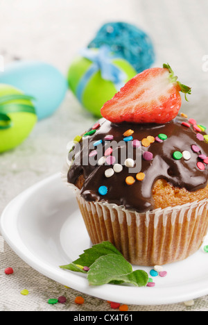 Chocolate sprinkle muffin with strawberry on the top on the plate Stock Photo