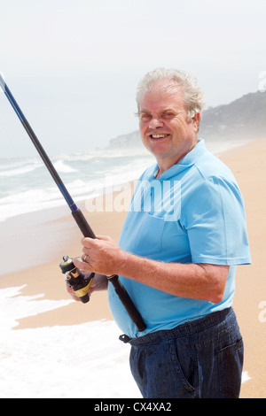 Old man fishing. Senior gray haired fisherman throws a spinning