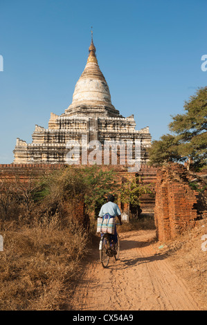 Man riding bicycle through outer gate, Dhamma-Yangyi Temple (Dhammayangyi), Bagan, Myanmar (Burma) Stock Photo