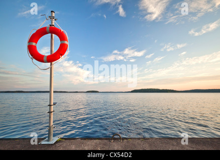 Safety equipment. Bright red safe lifebuoy on the pier Stock Photo