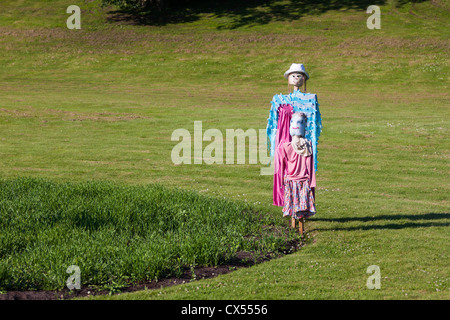 Two scarecrows stand together in the garden Stock Photo