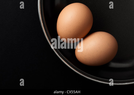 Two Brown Chicken Eggs on Black Frying Pan Stock Photo
