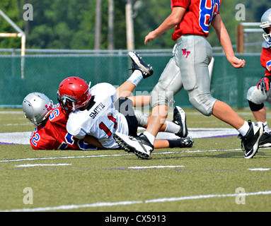 Young boys on the ground after a tackle during a football game. Stock Photo