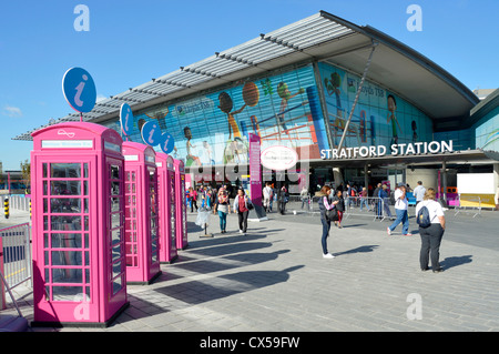 UK Telephone boxes painted Olympic pink & adapted as information points for London 2012 games on the forecourt of Stratford train station East London Stock Photo