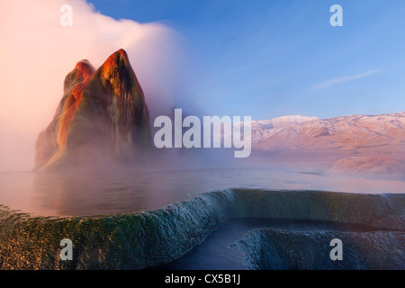 Fly Geyser with snow capped Granite Range in the Black Rock Desert near Gerlach, Nevada, USA Stock Photo