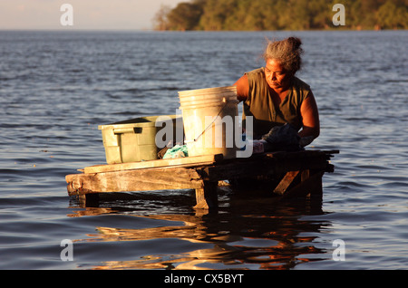 Local woman washes clothes in Lago Nicaraua at Ometepe Island  The worlds largest volcanic island inside a fresh water lake Stock Photo