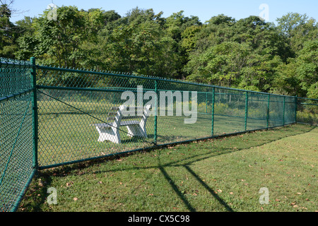 green cyclone fence with bench behind Stock Photo