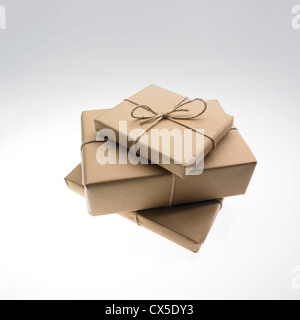 Three parcels wrapped in brown paper and tied up with string Stock Photo