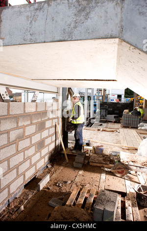 bricklayer building wall on construction site Stock Photo