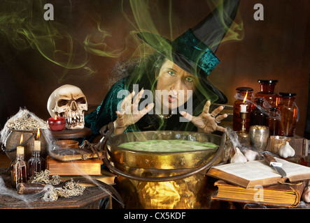 Ugly old halloween witch casting a spell over her cauldron Stock Photo