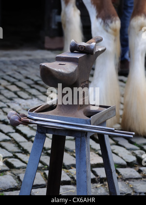 Farriers anvil, tools and legs of a Clydesdale horse. Stock Photo