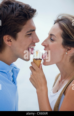 A young couple sharing an ice cream cone Stock Photo