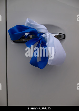 Wedding ribbons on the door of vehicle, UK Stock Photo