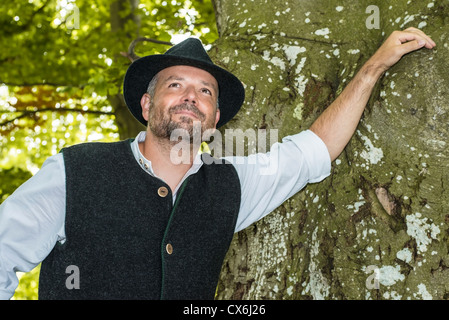 Man with Bavarian tradition standing in a forest Stock Photo