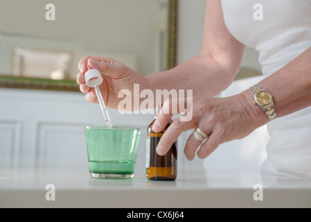 Health issues and people, mature woman with prescription medicine and water. Cropped view Stock Photo