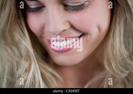 http://l450v.alamy.com/450v/cx6kwt/a-young-blonde-woman-looking-down-smiling-cx6kwt.jpg