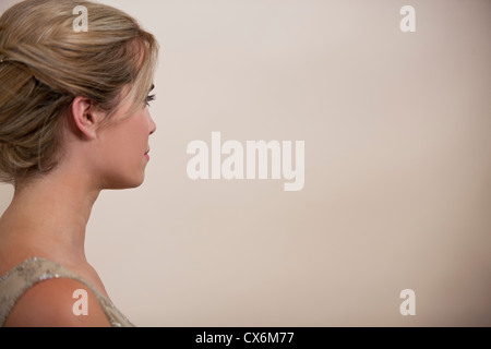 A young woman with her hair up, looking away Stock Photo