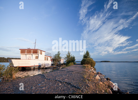 Small white pleasure boat moored on Saimaa lake in Imatra town, Finland Stock Photo