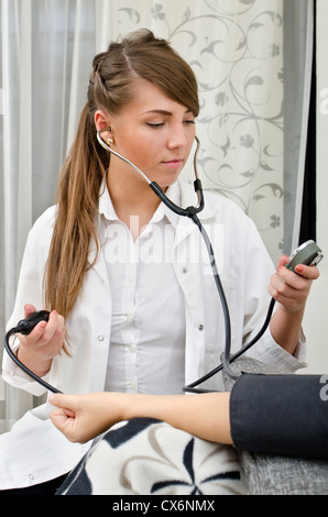 Female doctor measures patient's blood pressure Stock Photo