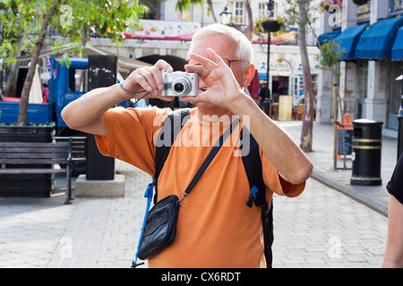 Senior man tourist taking photos using compact camera. Stock Photo