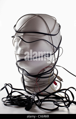A white mannequin bust entangled in various cords and cables Stock Photo