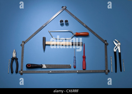 A folding ruler arranged to look like a house with various work tools Stock Photo