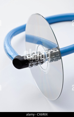 A combination bicycle lock threading through a compact disc Stock Photo