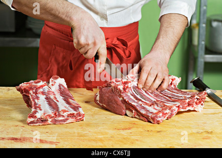 Detail of a man chopping meat Stock Photo