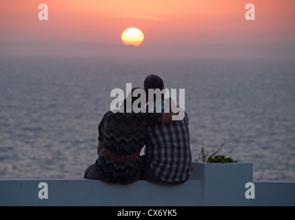 A couple watching the sun setting over the sea. 2012. Stock Photo
