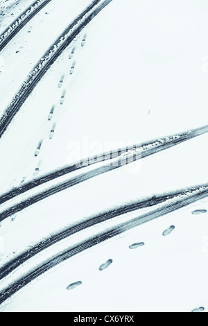 High Angle View of tire tracks and footprints in snow Stock Photo
