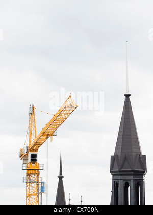 Urban development in Stockholm, steel crane next to old tower Stock Photo